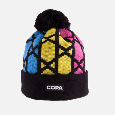 Black COPA beanie with blue, yellow, and pink geometric pattern, pom-pom on top, and COPA logo patch on the cuff
