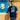 Model wearing the Maradona x COPA Boca Football Sticker T-Shirt, standing against a blue and yellow background with Maradona artwork.