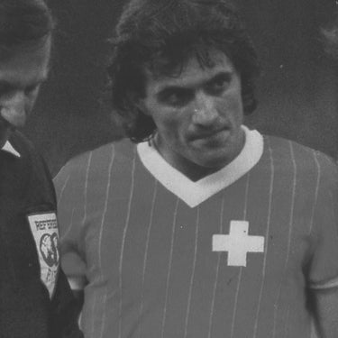Vintage black-and-white photograph of a Swiss football player wearing the 1982 shirt.