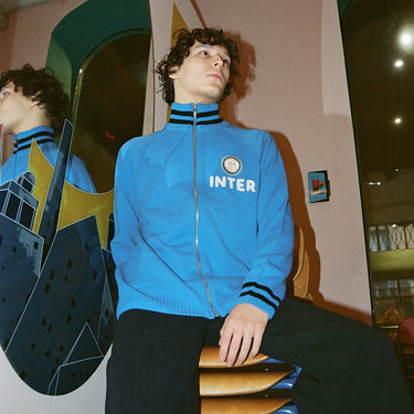 Young man wearing the blue Inter Milan track jacket in a modern indoor setting