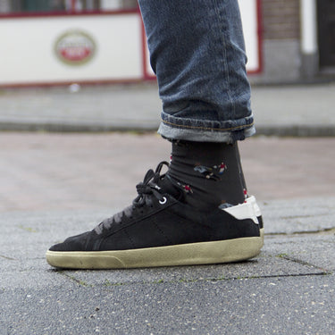 model wearing casual grey socks with a repeating pixel-style illustration of antonin panenka doing the panenka in 1976