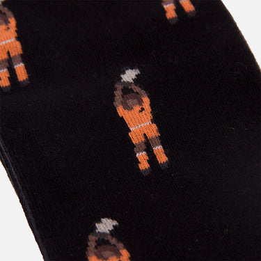 detail of casual green socks with a repeating pixel-style illustration of a guillit holding a trophy above his head refers to holland 1988