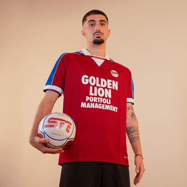 Servette FC 1998 - 99 Retro Football Shirt Burgundy & Blue Lifestyle worn by a model holding a football in a studio setting.