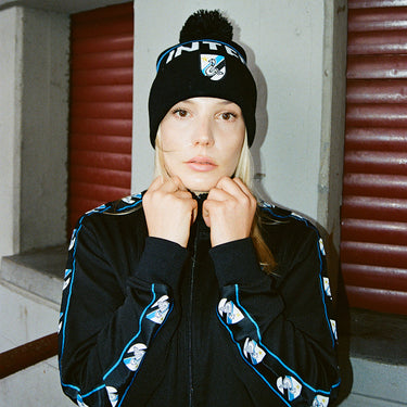 Model wearing the black Inter beanie with matching tracksuit in an urban setting