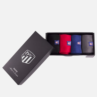 Box with three folded socks in blue, red, and black featuring club logos  
