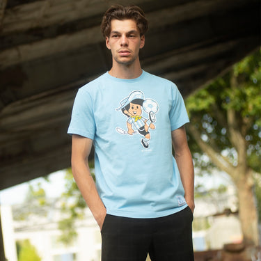 Model wearing the Gauchito T-shirt, standing under a bridge, showcasing the stylish and nostalgic FIFA World Cup design.