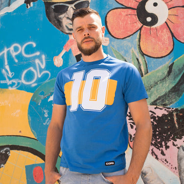 Model wearing the Boca Number 10 T-Shirt, standing against a colorful mural backdrop.