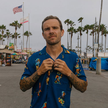 Model wearing the Calcio Donna Camp Collar Shirt outdoors, buttoning it up.