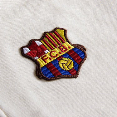 Close-up of retro FC Barcelona crest on 1899 Ecru Half Zip Sweater
